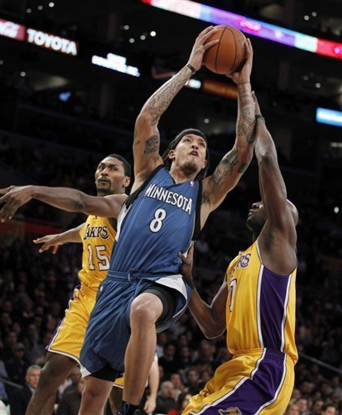Minnesota Timberwolves forward Michael Beasley, center, drives to the basket as he is defended by Los Angeles Lakers' Ron Artest, left, and Lamar Odom during the first half of an NBA basketball game in Los Angeles, Tuesday, Nov. 9, 2010. (AP Photo/Jae C. Hong)