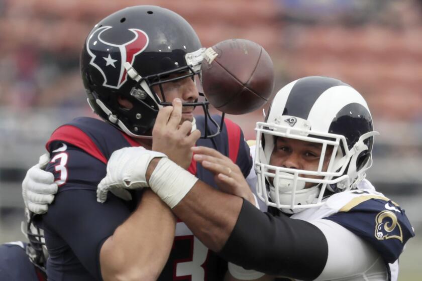 Rams defensive lineman Aaron Donald knocks the ball from Texans quarterback Tom Savage for a fumble early in the first quarter.