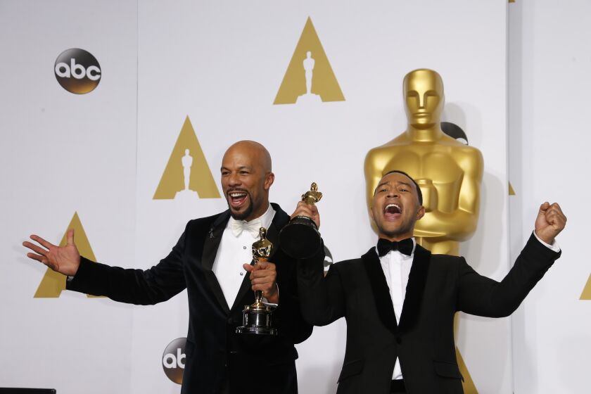 Rapper Common and musician John Legend hold Oscars for best song backstage at the Academy Awards.