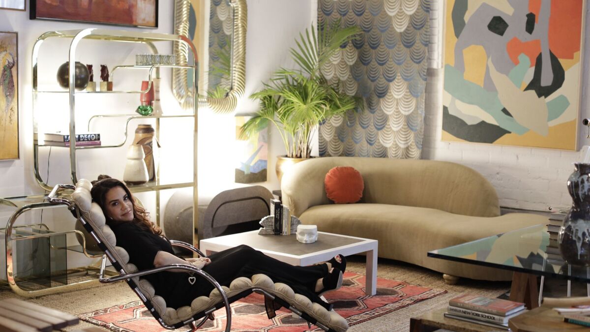 Tricia Beanum reclines on a Mies van der Rohe lounge chair inside her warehouse store Pop Up Home in West Adams.