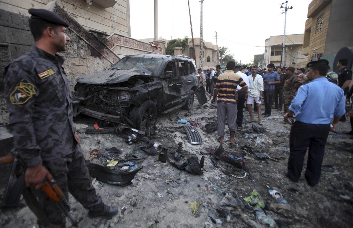 Security forces inspect the scene of a car bomb attack in Basra, Iraq.