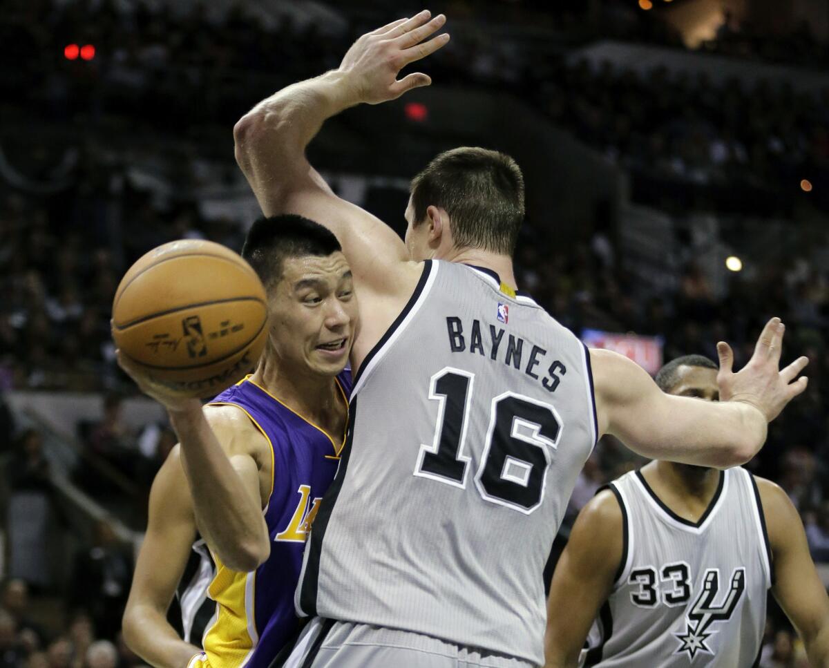 Lakers point guard Jeremy Lin looks to pass after having his drive cut off by Spurs center Aron Baynes in the first half.