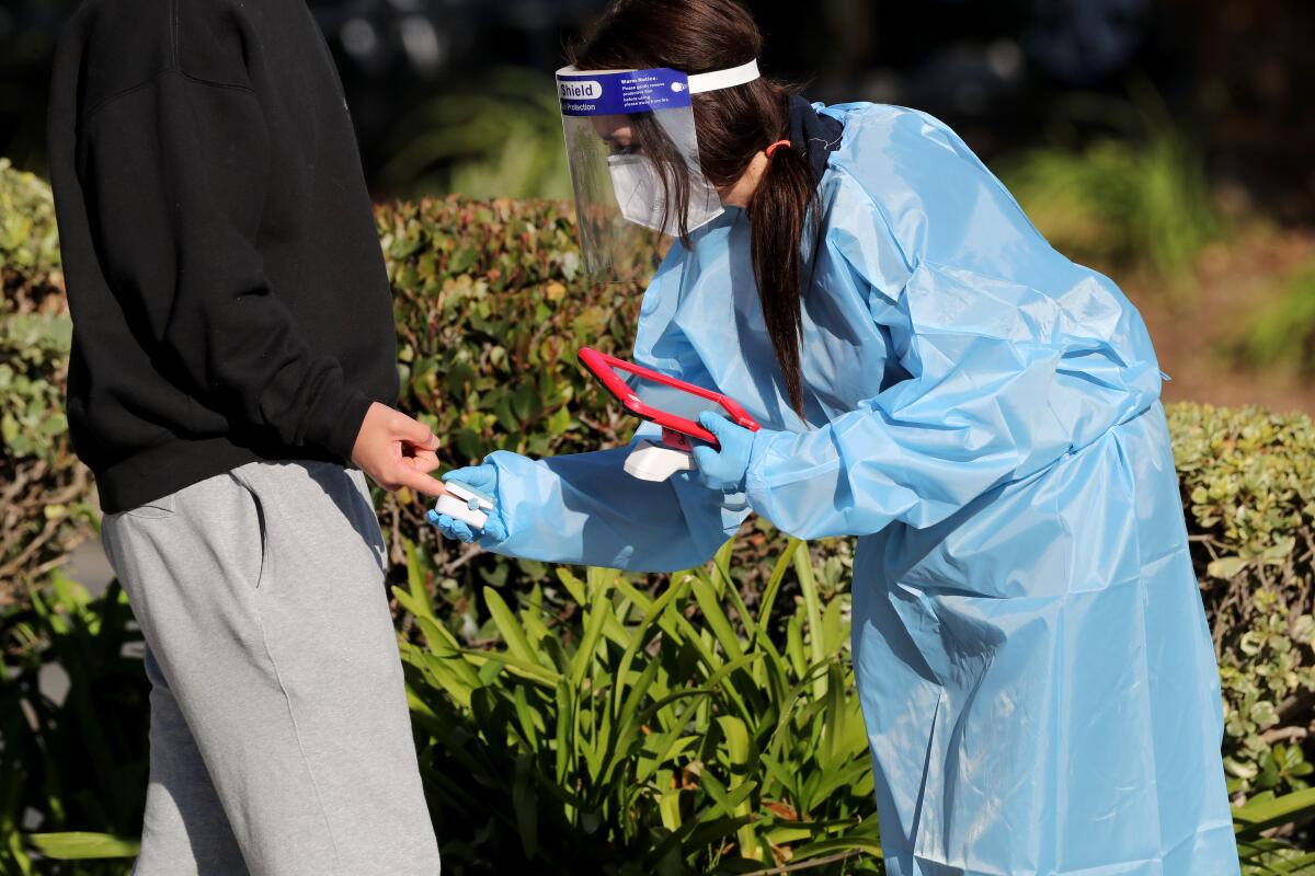 Area residents have their vitals checked by health professionals at a COVID-19 testing kiosk in Costa Mesa