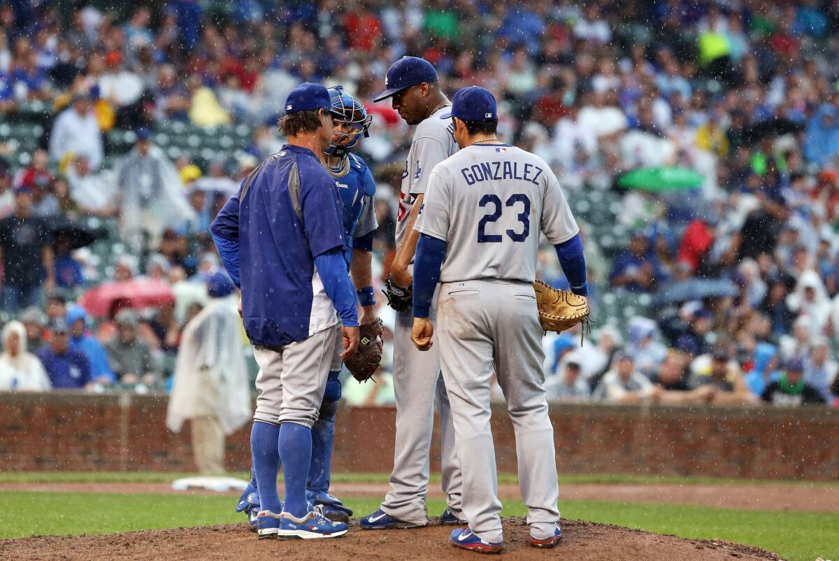 Don Mattingly has a conference on the mound with pitcher Roberto Hernandez and his fellow Dodger teammates during the fifth inning. The Dodgers lost to the Cubs, 8-7.