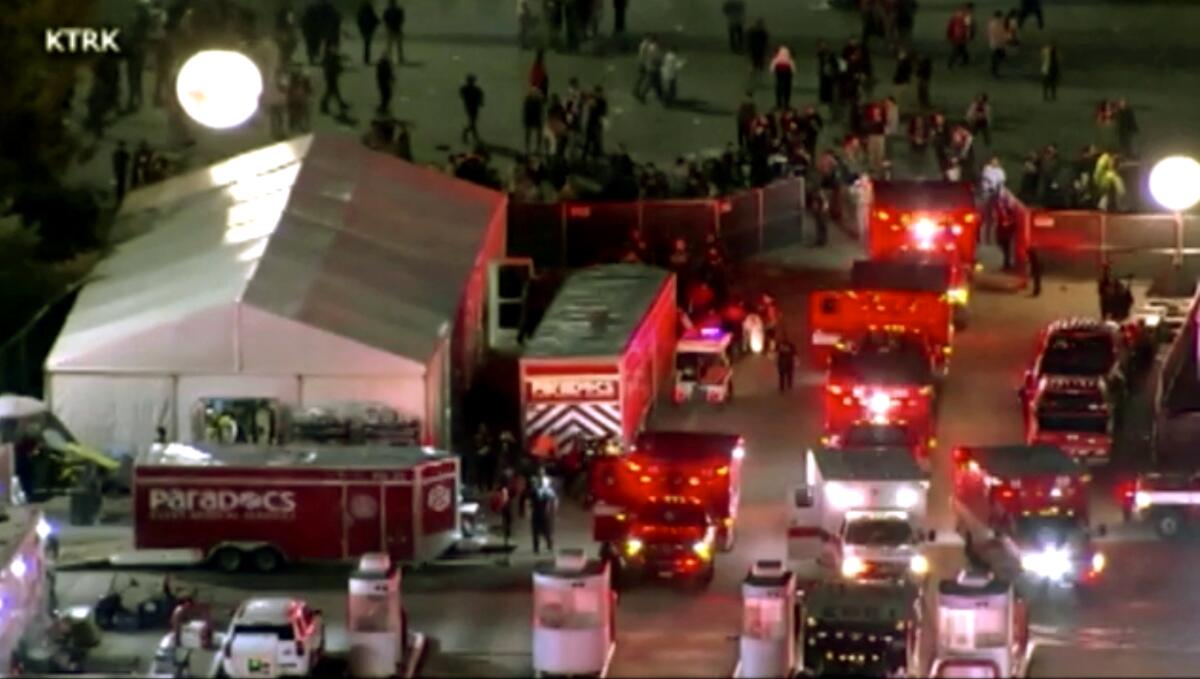 Aerial view of several ambulances lined up in a parking lot at an event venue at night