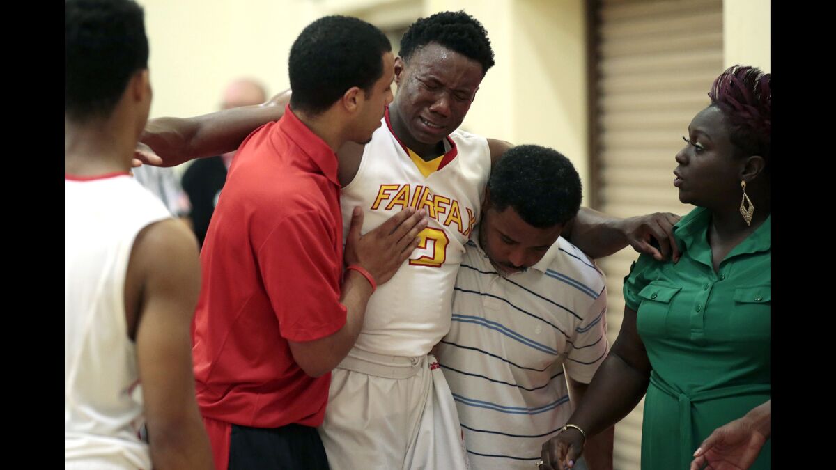 Fairfax forward Donald Gipson is helped off the court after injuring his knee early in the first half against Etiwanda in the Southern California Regionals Open Division semifinal at Fairfax High School on Tuesday.