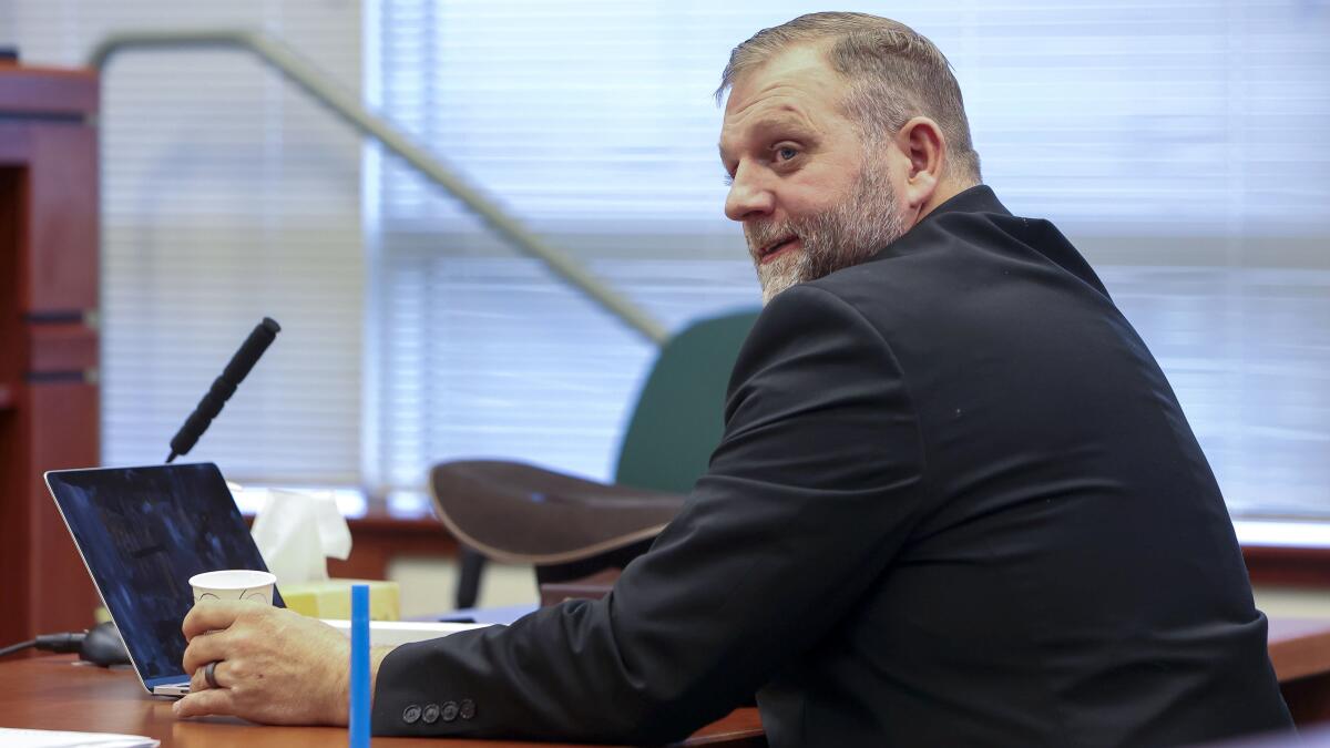 Ammon Bundy looks up from a laptop in court.