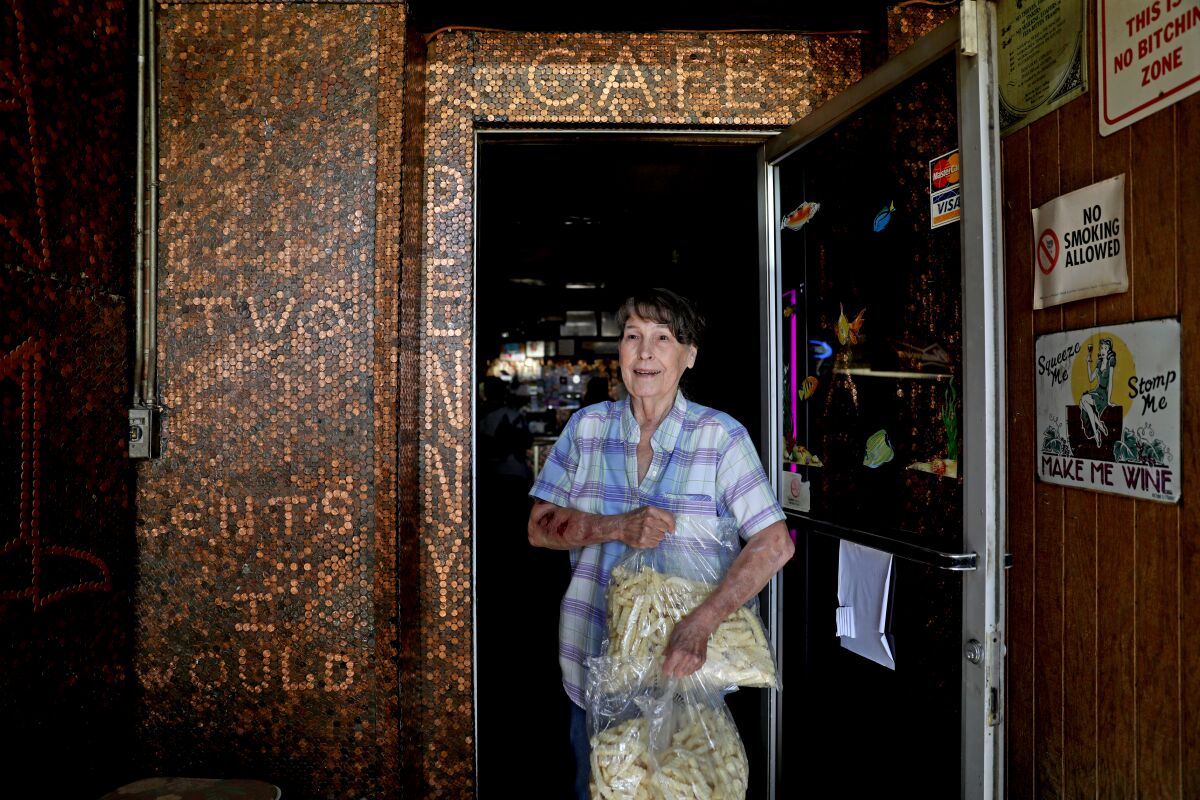 A woman stands in the doorway of a cafe