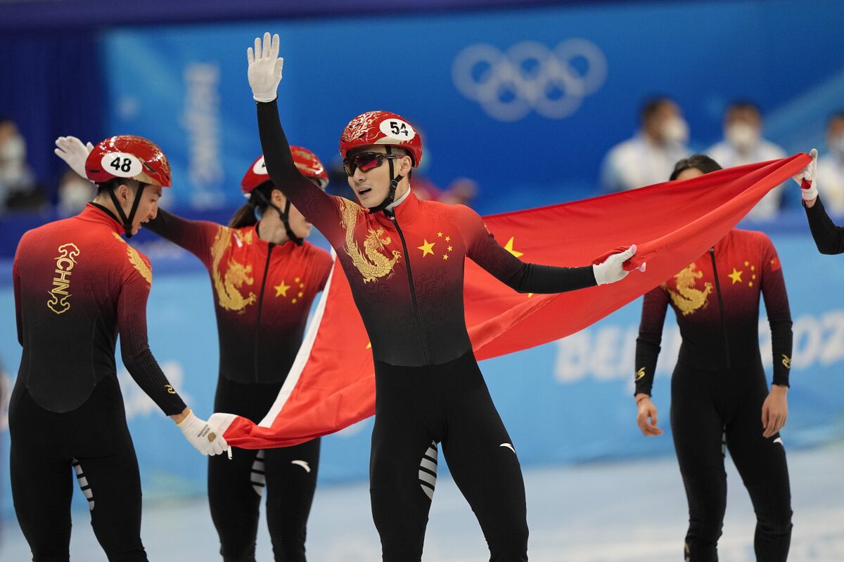 Ren Ziwei of China celebrates with teammates after they won the mixed team relay final during the short track speedskating competition at the 2022 Winter Olympics, Saturday, Feb. 5, 2022, in Beijing. (AP Photo/David J. Phillip)