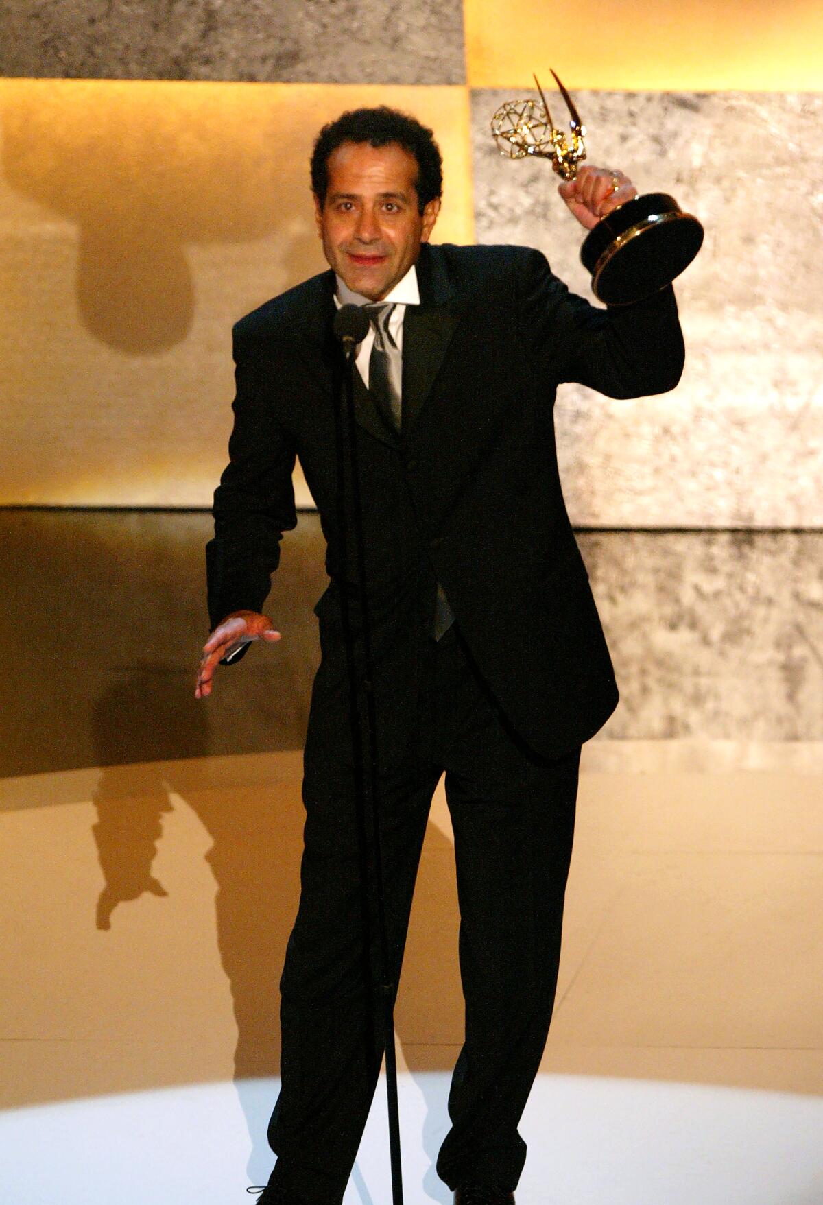 Tony Shalhoub hoists his Emmy Award onstage at the 2003 ceremony.