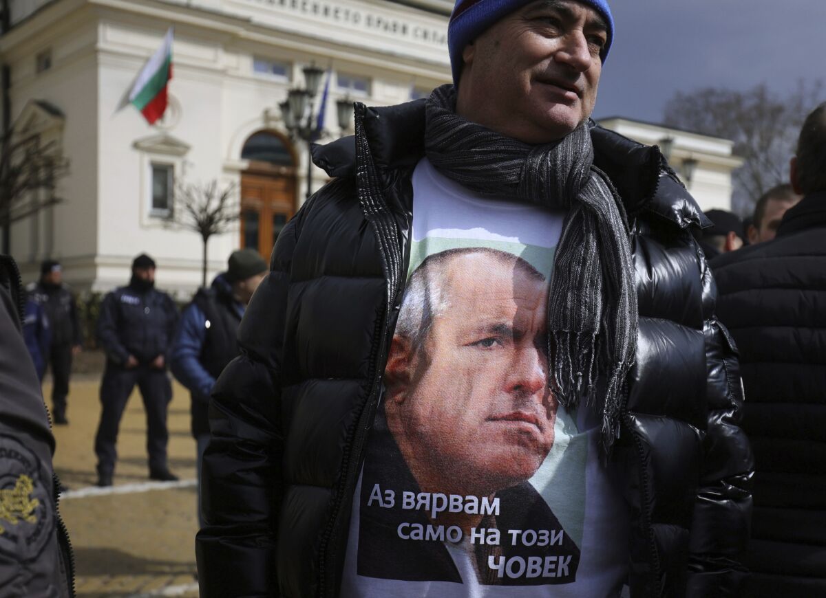 A supporter of former Prime Minister Borissov wears a T-shirt with his image with text reading in Bulgarian) "I trust only this man," during a demonstration in front of Bulgarian Parliament, Sofia, Friday, March 18, 2022. Bulgarian ex-Prime Minister Boyko Borissov remained in custody on Friday following corruption investigations by European Union prosecutors as his supporters took to the streets to protest his detention. The Interior Ministry said late Thursday that Borissov was being detained for 24 hours in a nationwide police operation that also targeted other former officials. (AP Photo/Valentina Petrova)