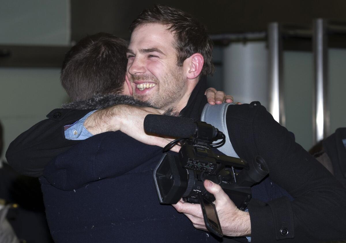 Journalist Kieron Bryan, right, who was detained in Russia with Greenpeace activists, embraces his brother Russell at St. Pancras train station in London after his release.
