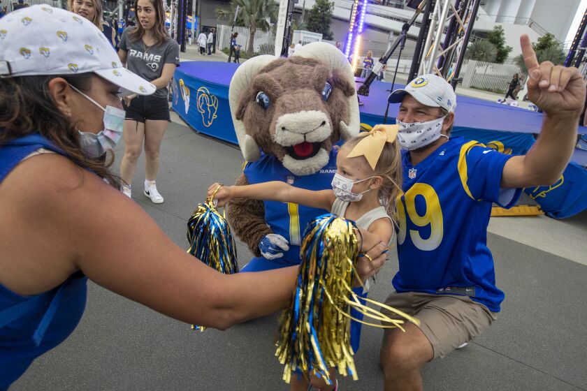 INGLEWOOD, CA - AUGUST 14, 2021- Jason Razon, right, and daughter Livie, 6, take a photo with Rams mascot Rampage before the Rams vs. Chargers game at SoFi Stadium Saturday, Aug. 14, 2021 in Inglewood, CA. (Brian van der Brug / Los Angeles Times)