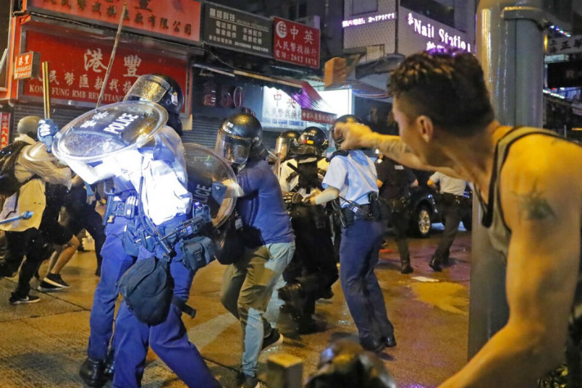 A man tosses a brick at policemen during a protest in Hong Kong on Sunday.