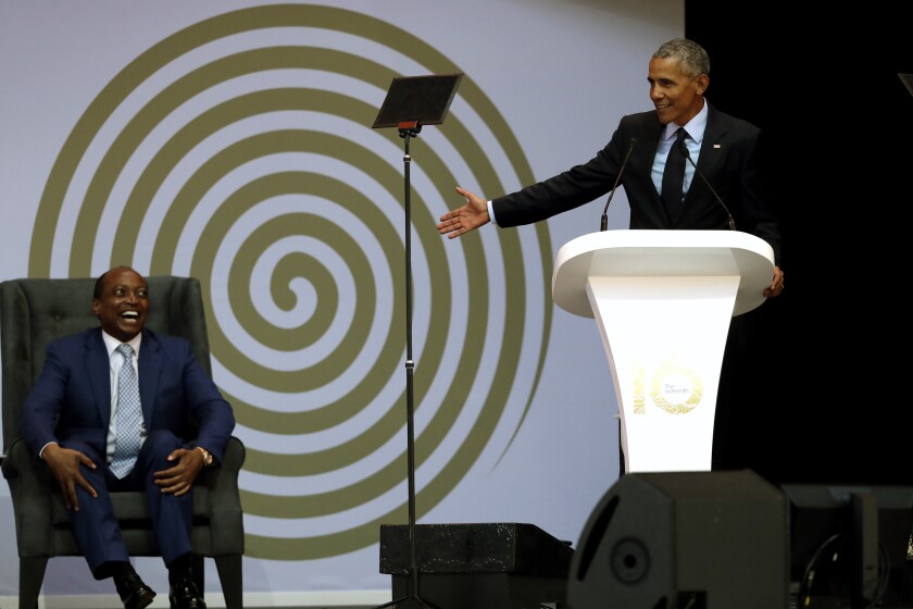 FILE - in this file photo dated Tuesday, July 17, 2018, former U.S. President Barack Obama, right, delivers his speech, as Patrice Motsepe, left, looks on at the 16th Annual Nelson Mandela Lecture at the Wanderers Stadium in Johannesburg, South Africa. The election to lead African soccer is seeming to be dominated by FIFA president Gianni Infantino, who supports South African billionaire Patrice Motsepe to win the top job in a ballot next week. (AP Photo/Themba Hadebe, FILE)