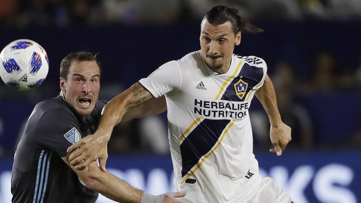 Galaxy forward Zlatan Ibrahimovic, right, battles Minnesota United defender Brent Kallman for the ball during a match in August.