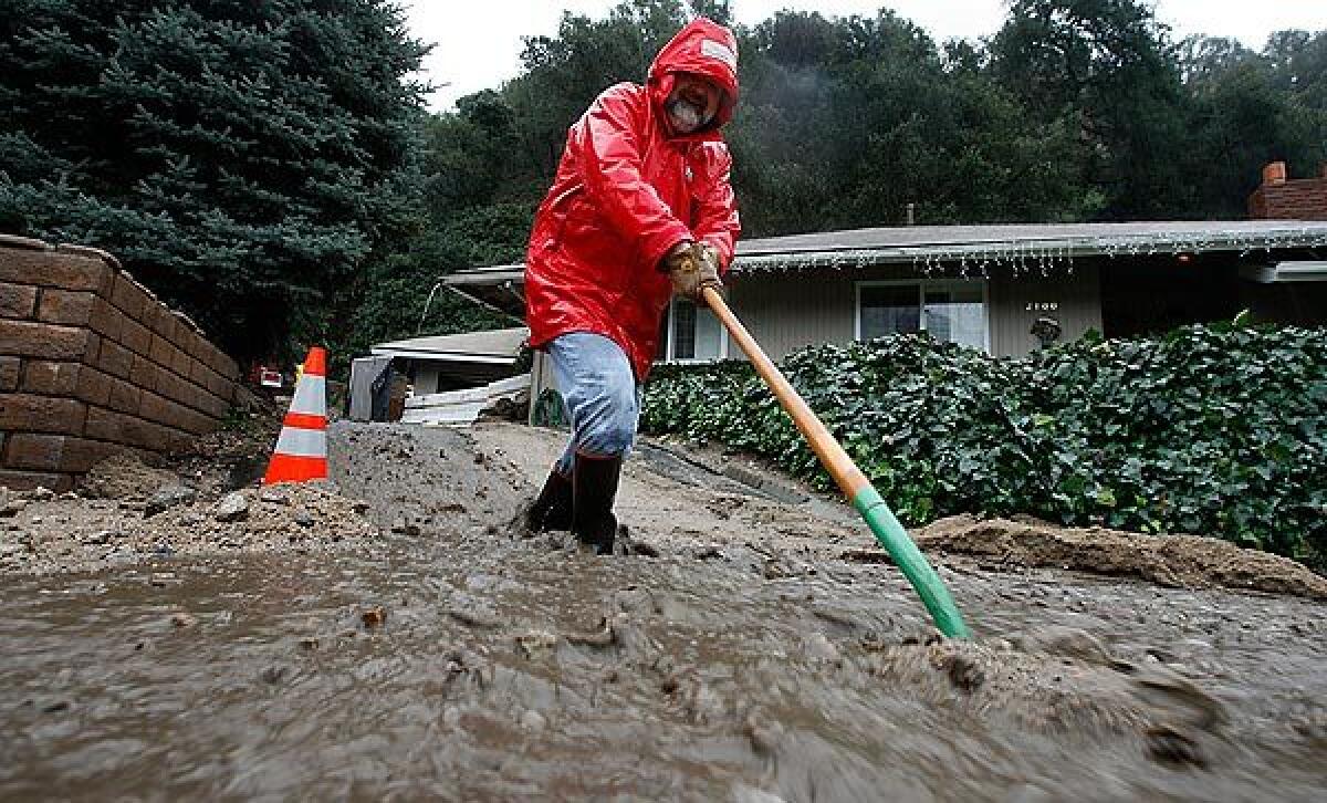 Homeowner George Wiktor in winter 2009 clears mud away so water can flow past his property on Earnslow Drive in La Cañada Flintridge. Officials ordered the evacuation of 251 homes after three storms over a four-day period pounded on the area left vulnerable to mudslides in the wake of the 2009 Station fire.