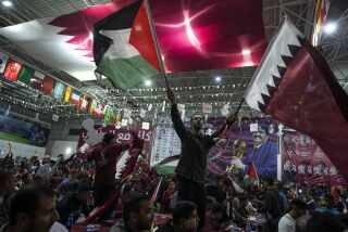 En esta imagen de archivo, aficionados ondean banderas qataríes y palestinas durante una transmisión del primer partido del Mundial, entre Qatar y Ecuador, en un gimnasio en la Ciudad de Gaza, el 20 de noviembre de 2022. (AP Foto/Fatima Shbair, archivo)