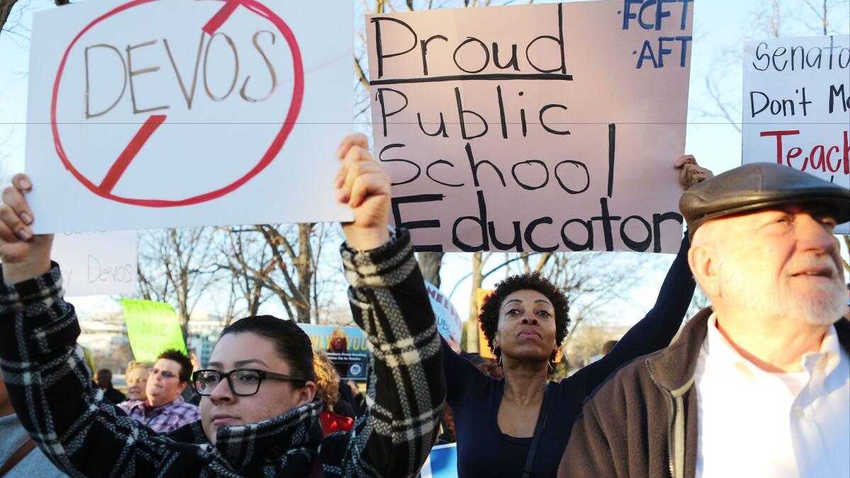 Protesters demonstrate against Betsy DeVos in Washington on Monday.