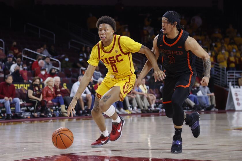 Southern California guard Boogie Ellis (0) drives past Pacific guard Pierre Crockrell II (3) during the second half of an NCAA college basketball game Tuesday, Feb. 8, 2022, in Los Angeles. Southern California won 74-68. (AP Photo/Ringo H.W. Chiu)