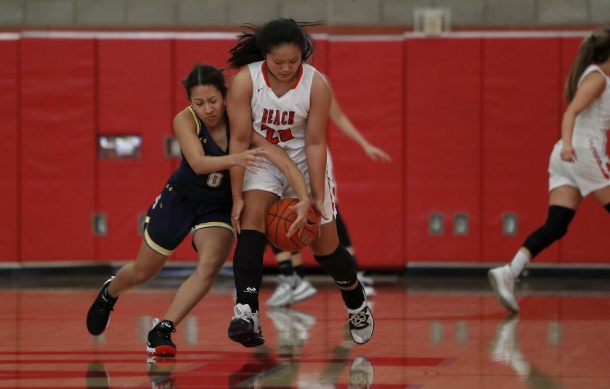 Huntington Beach’s Marisa Tanga, right, steals the ball from Sonora’s Maiya Wells during the first half of a Matt Denning Classic game at Mater Dei High on Jan. 4.
