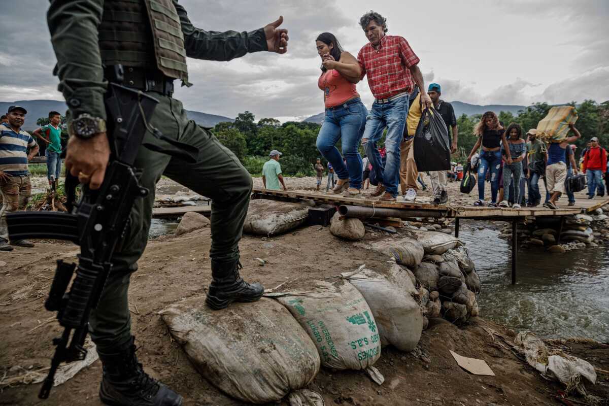 Un policía colombiano vigila a los venezolanos que cruzan la frontera de San Antonio del Táchira a Colombia a través de caminos ilegales cerca del puente internacional Simón Bolívar.