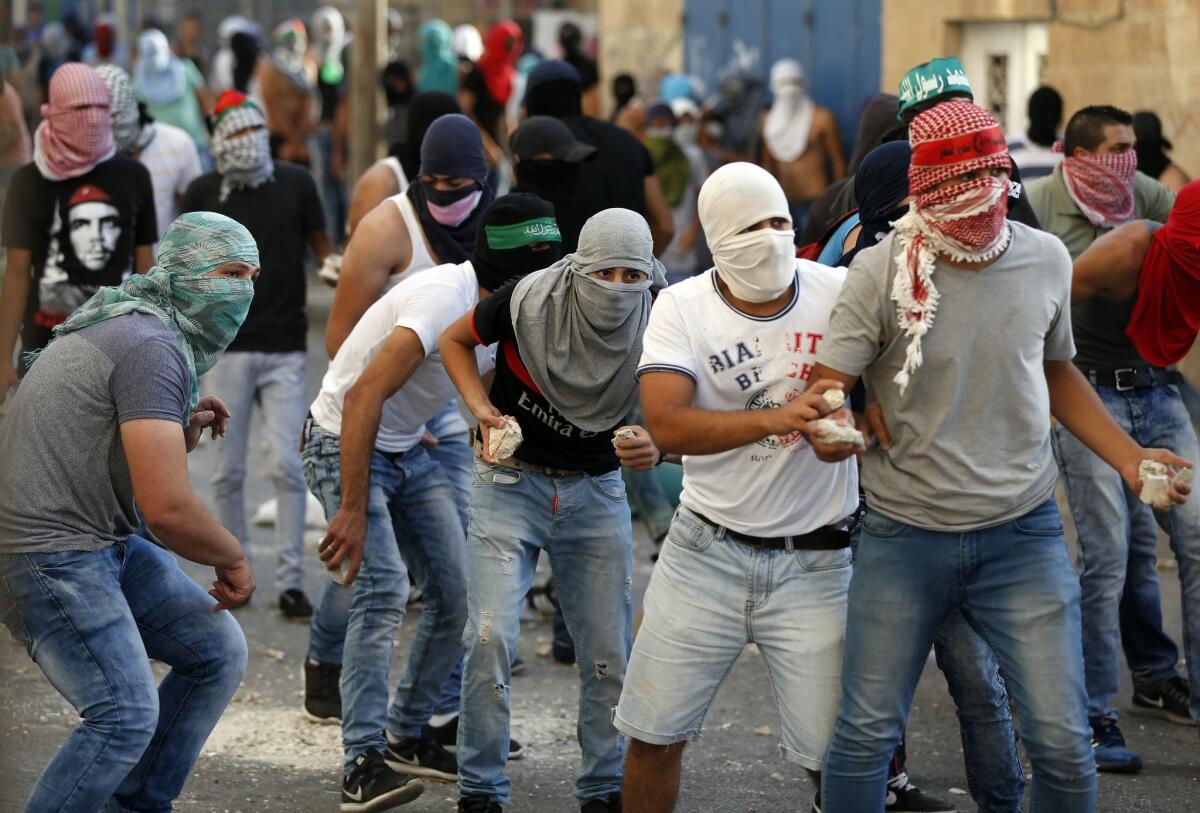 Palestinian throw stones during clashes with Israeli security forces in the Palestinian neighborhood of Shuafat in east Jerusalem.