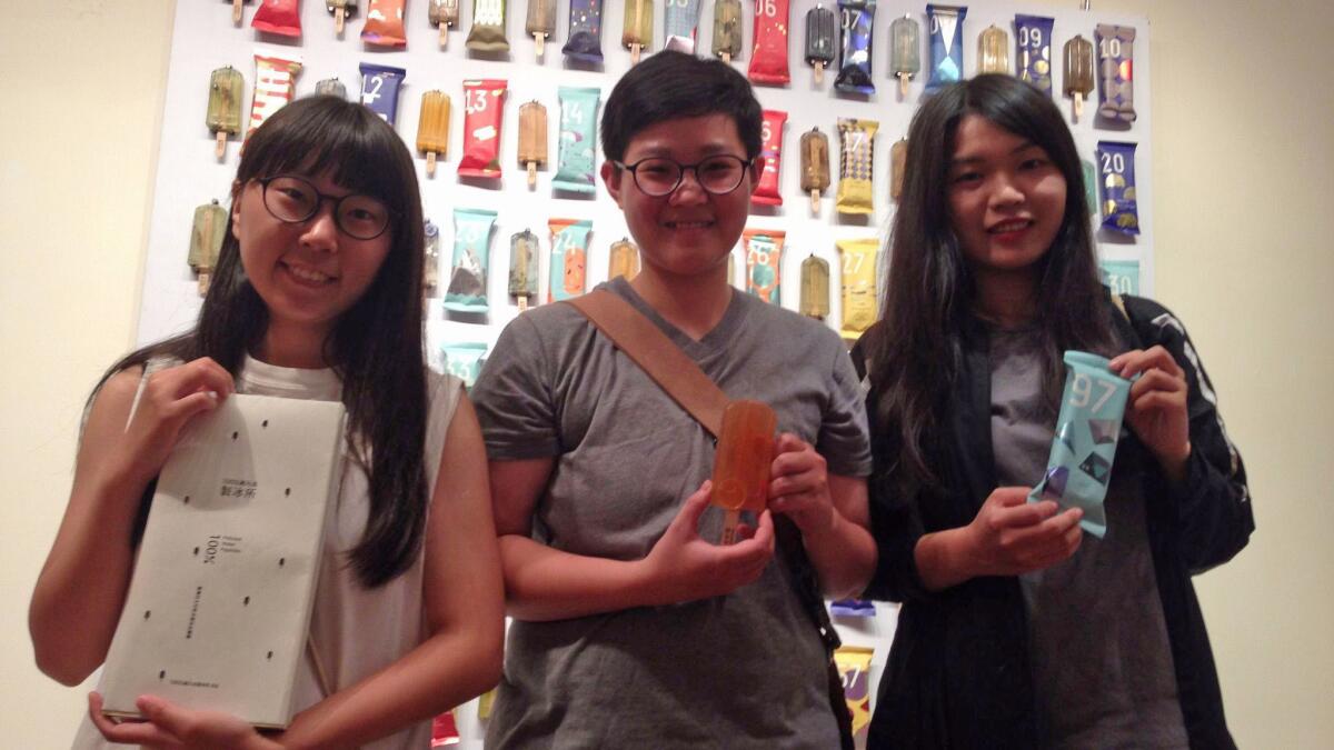National Taiwan University of Arts students, from left, Kuo Yi-hui, Hung Yi-chen and Cheng Yu-di pose with their book and two popsicles.