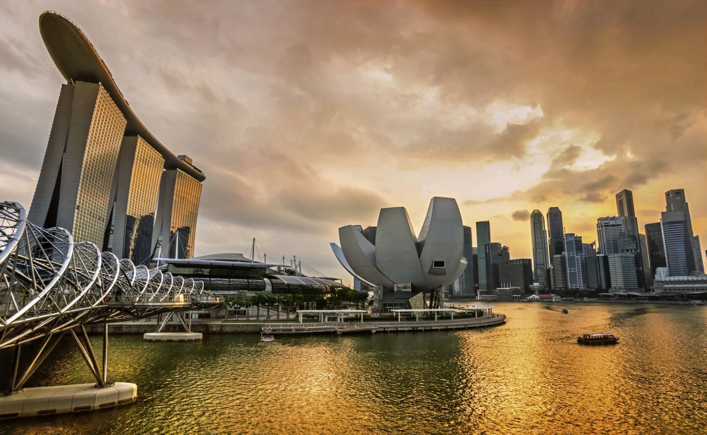 The dramatic Singapore city skyline at sunset, with the striking Marina Bay Sands Hotel to the left, three towers with a Skypark atop them. On Aug. 9, 2015, Singapore celebrates its golden jubilee.