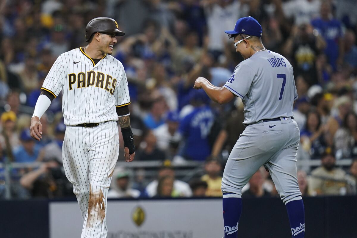 San Diego Padres' Manny Machado jokes with Dodgers pitcher Julio Urias.