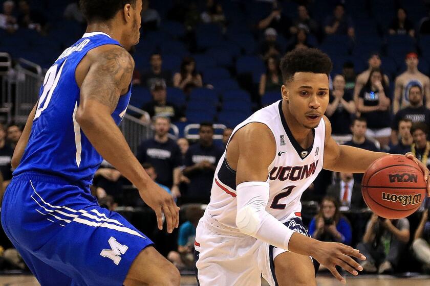 Connecticut guard Jalen Adams tries to drive against Memphis guard Ricky Tarrant Jr. during the American Athletic Conference championship game Sunday.