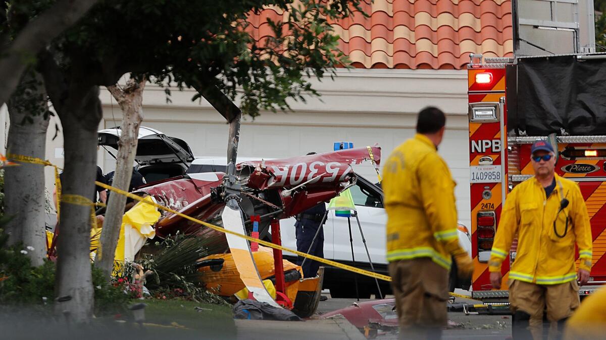 Police investigate the scene where three people were killed and two others were injured when a four-seat Robinson R44 helicopter crashed into a Newport Beach home Jan. 30.