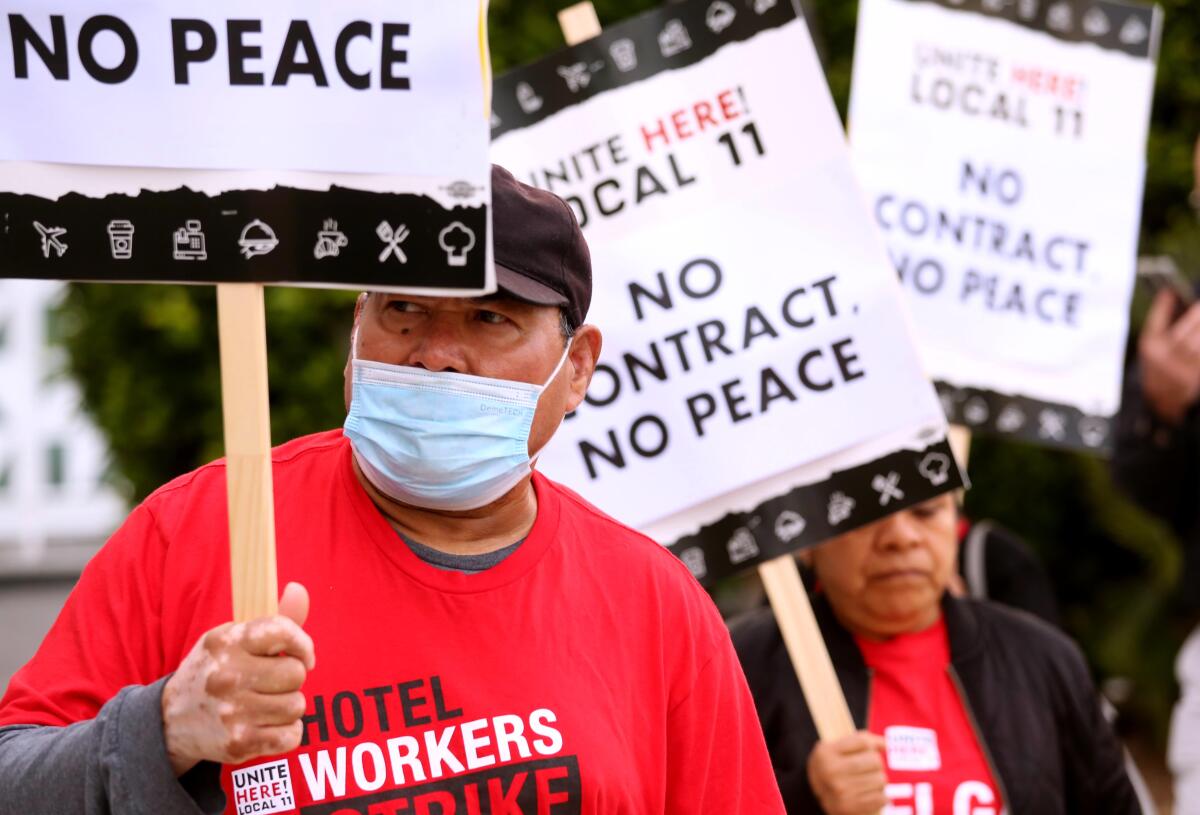 hotel workers hold picket signs