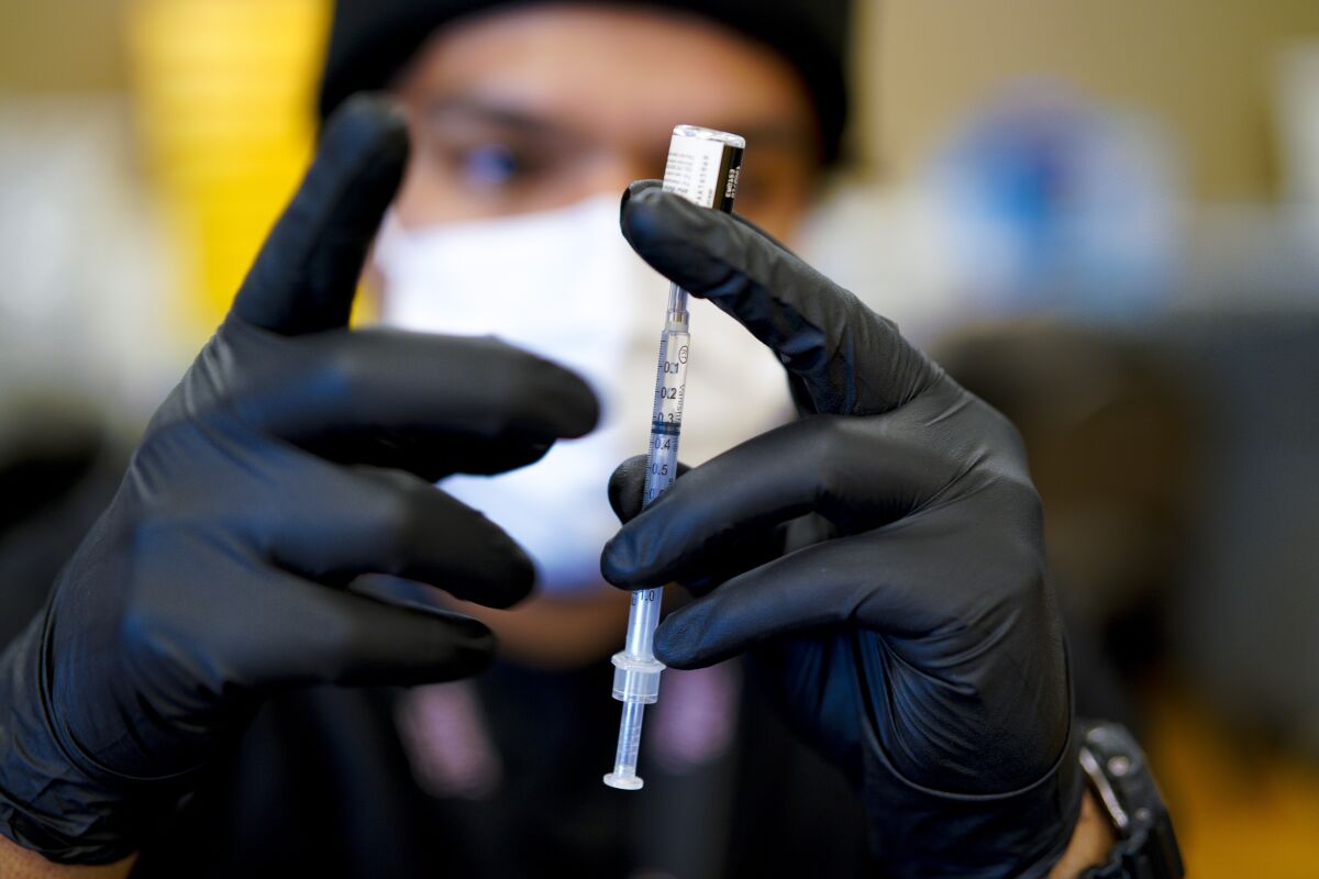Pharmacy Tech Daniel Zazueta prepares a syringe with the COVID-19 vaccine in Chula Vista in 2021.
