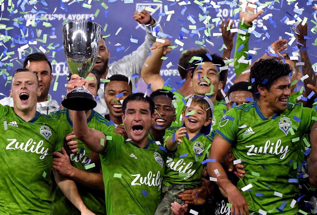 Nicolas Lodeiro, center, celebrates with his Seattle Sounders teammates following their 3-1 win over LAFC in the MLS Western Conference final.
