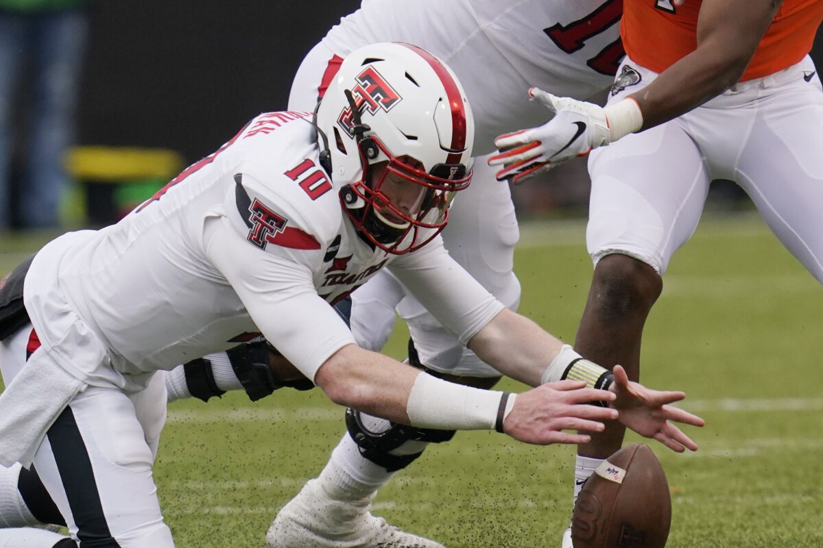 Texas Tech quarterback Alan Bowman (10) recovers his own fumble in the second half of an NCAA college football game against Oklahoma State in Stillwater, Okla., Saturday, Nov. 28, 2020. (AP Photo/Sue Ogrocki)