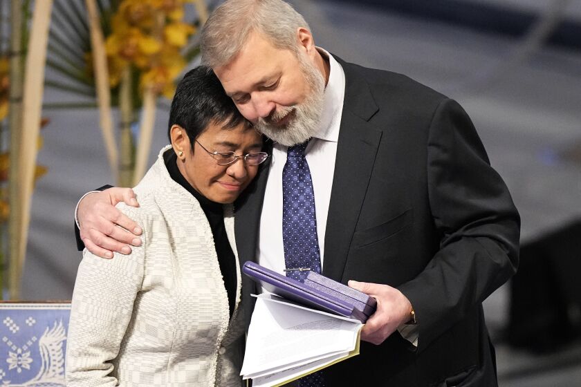 FILE - Nobel Peace Prize winners Dmitry Muratov from Russia, right, and Maria Ressa of the Philippines embrace during the Nobel Peace Prize ceremony at Oslo City Hall, Norway, Friday, Dec. 10, 2021. This year’s Nobel season approaches as Russia’s invasion of Ukraine has shattered decades of almost uninterrupted peace in Europe and raised the risks of a nuclear disaster. The famously secretive Nobel Committee never leaks or hints who will win its prizes for medicine, physics, chemistry, literature, economics or peace. So it is anyone’s guess who might win the awards that will be announced starting next Monday, Oct. 3, 2022. (AP Photo/Alexander Zemlianichenko, File)