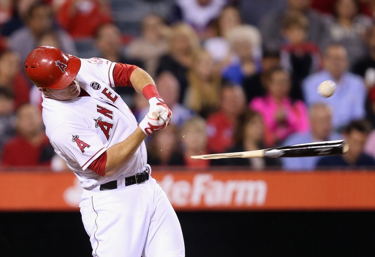 Mike Trout hits a broken-bat single in the fourth inning of the Angels' 3-2 extra inning victory over the Seattle Mariners on Friday.