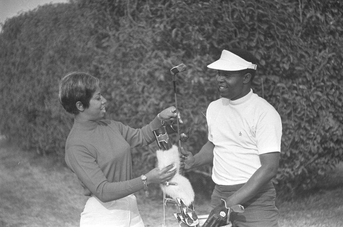 Two people with golf clubs.