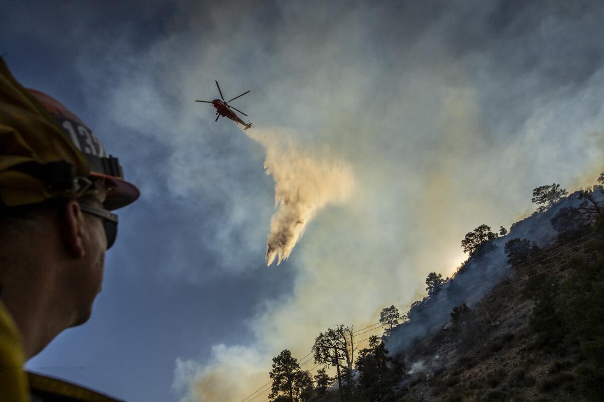 A water-dropping helicopter makes a drop on the Bobcat fire in Angeles National Forest in September 2020.