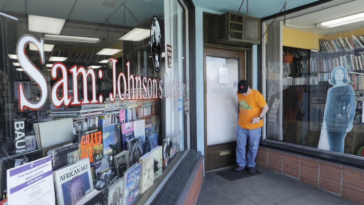 A customer leaving Sam: Johnson's Bookshop. The store sells used and rare books on everything from mummies to Dostoevsky.