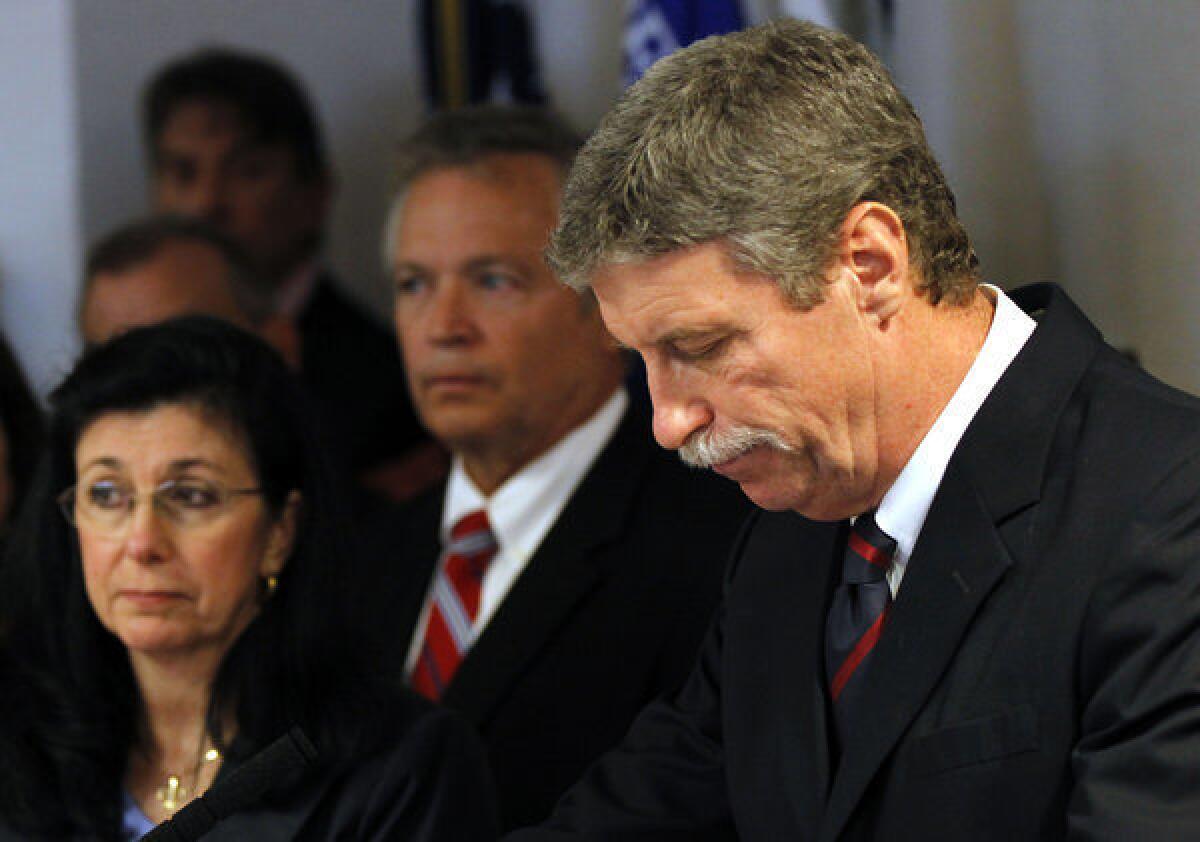 Federal prosecutor Jim Letten announces his resignation during a news conference in New Orleans. At far left is his wife, JoAnn.