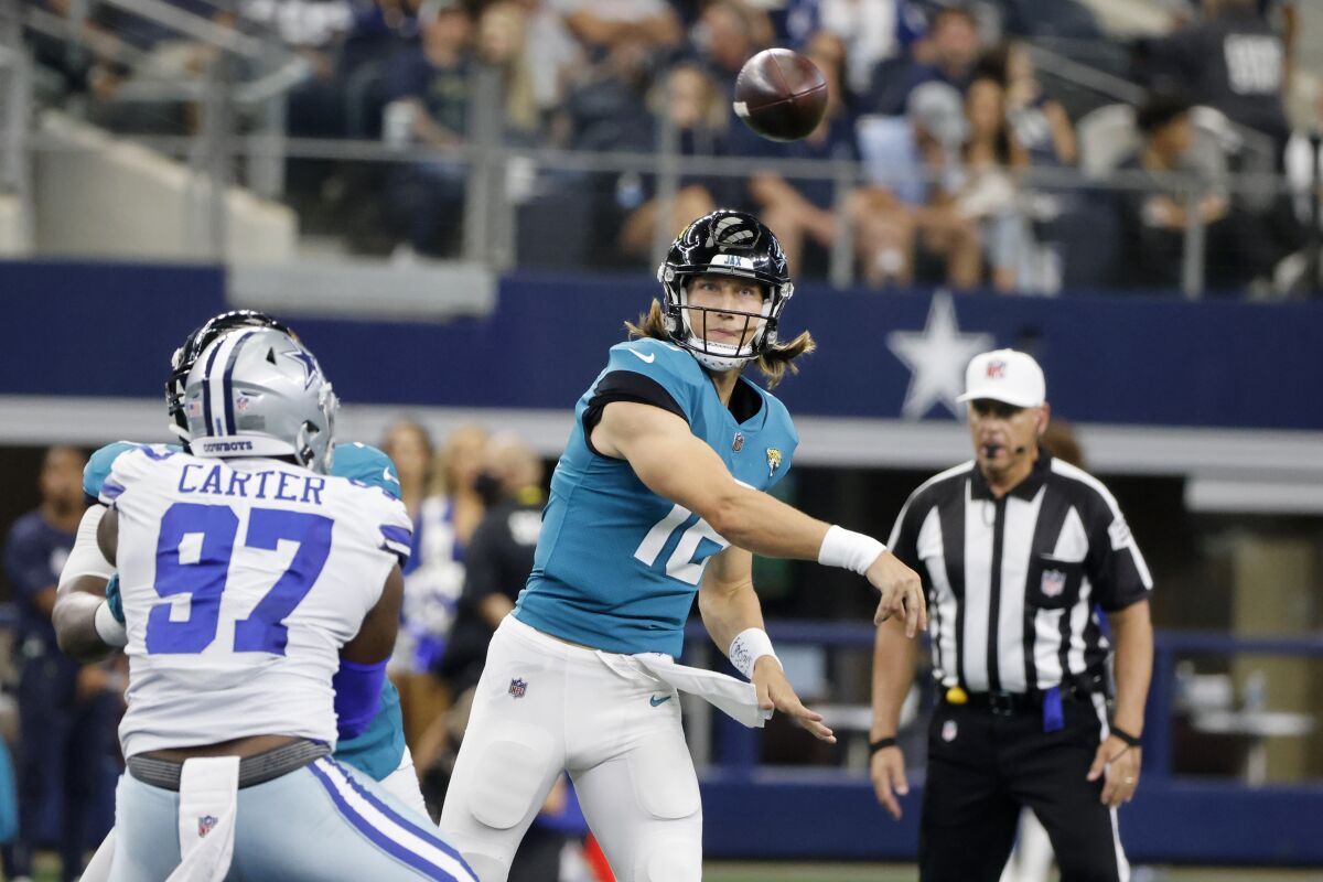 Dallas Cowboys defensive end Ron'Dell Carter (97) pressures as Jacksonville Jaguars quarterback Trevor Lawrence (16) throws a pass in the first half of a preseason NFL football game in Arlington, Texas, Sunday, Aug. 29, 2021. (AP Photo/Michael Ainsworth)