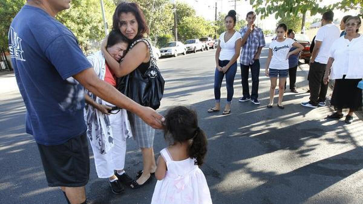 Loved ones grieve after a woman was fatally shot in Pacoima, one of three people killed in separate shootings Sunday in the San Fernando Valley.