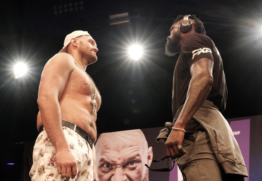 WBC heavyweight champion Tyson Fury, left, and Deontay Wilder face off at a news conference.