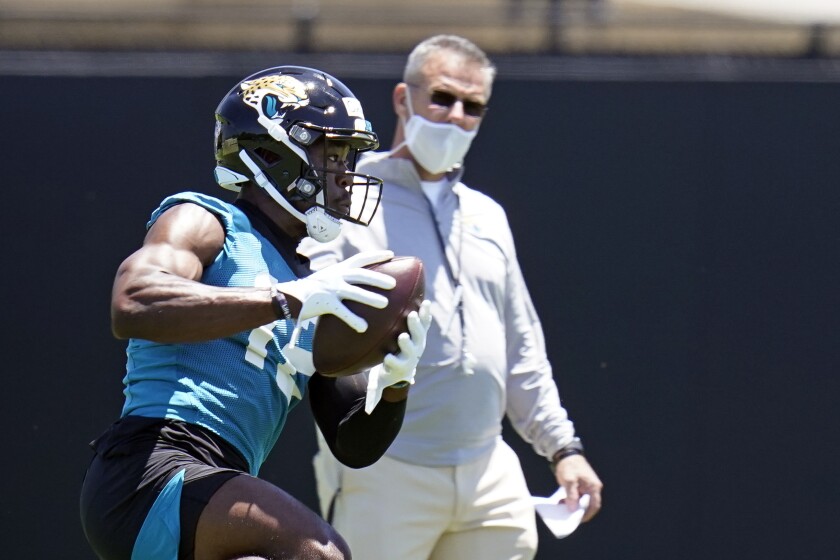 Jacksonville Jaguars wide receiver Jalen Camp, left, catches a pass as head coach Urban Meyer looks on during an NFL football rookie minicamp, Saturday, May 15, 2021, in Jacksonville, Fla. (AP Photo/John Raoux)
