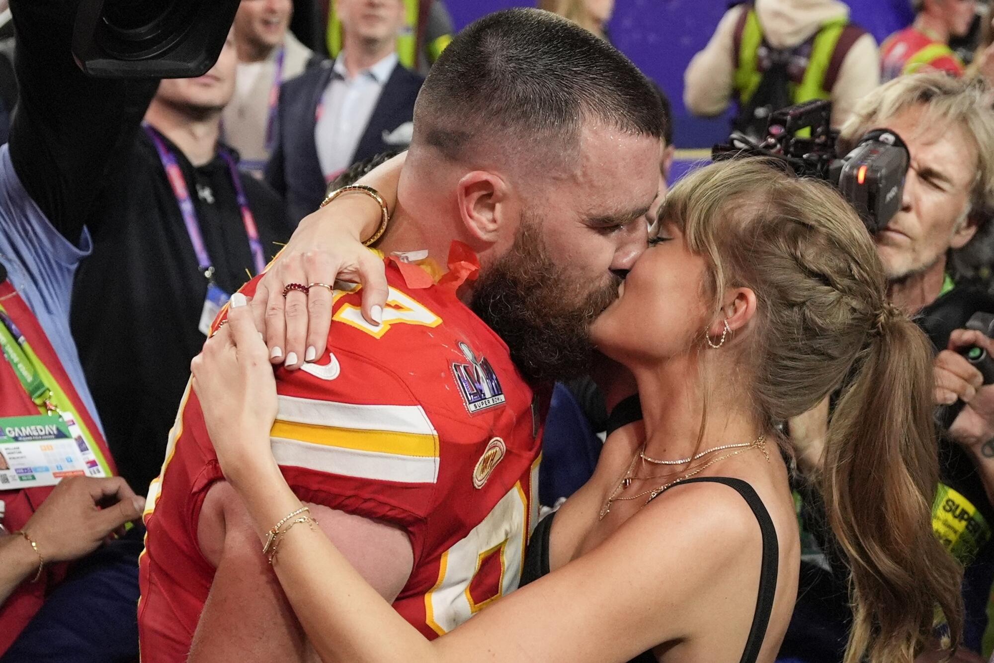 El ala cerrada de los Kansas City Chiefs, Travis Kelce (87), besa a Taylor Swift después del partido de fútbol 