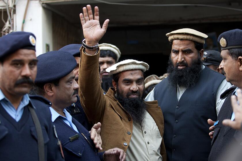 Pakistani police officers escort Zaikur Rehman Lakhvi after his court appearance in Islamabad in 2015.