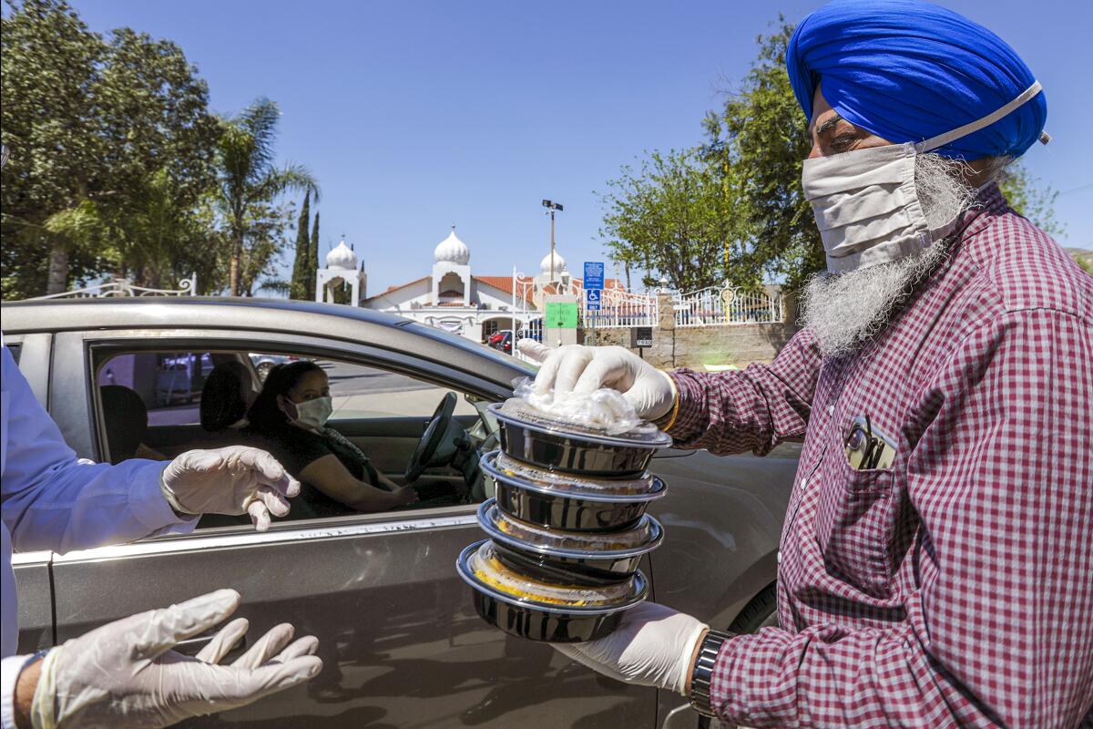 Balwinder Sidhu helps in a food distribution organized by the United Sikh Mission and the city's Sikh community on Thursday at Sikh Gurdwara in Riverside.
