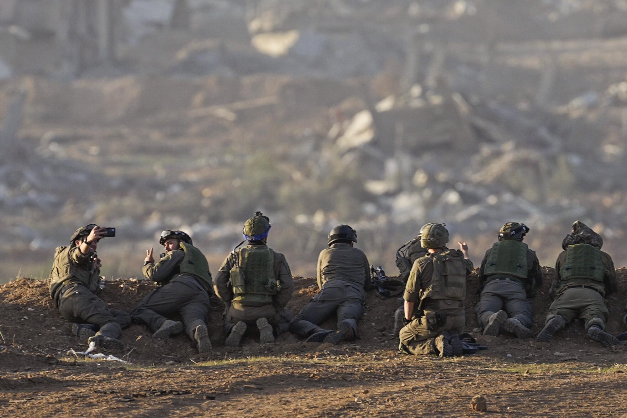 Israeli soldiers taking positions on the ground near Gaza